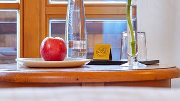 Een houten tafel met eten, een fles, een glas en een bloem.