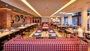 A restaurant with a modern interior, featuring wooden accents, checkered booths, and a variety of table settings.