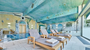 A poolside area with lounge chairs, a pool, and a staircase leading to an upper level.