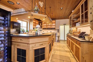 A kitchen with wooden cabinetry, a central island, and a wine rack.