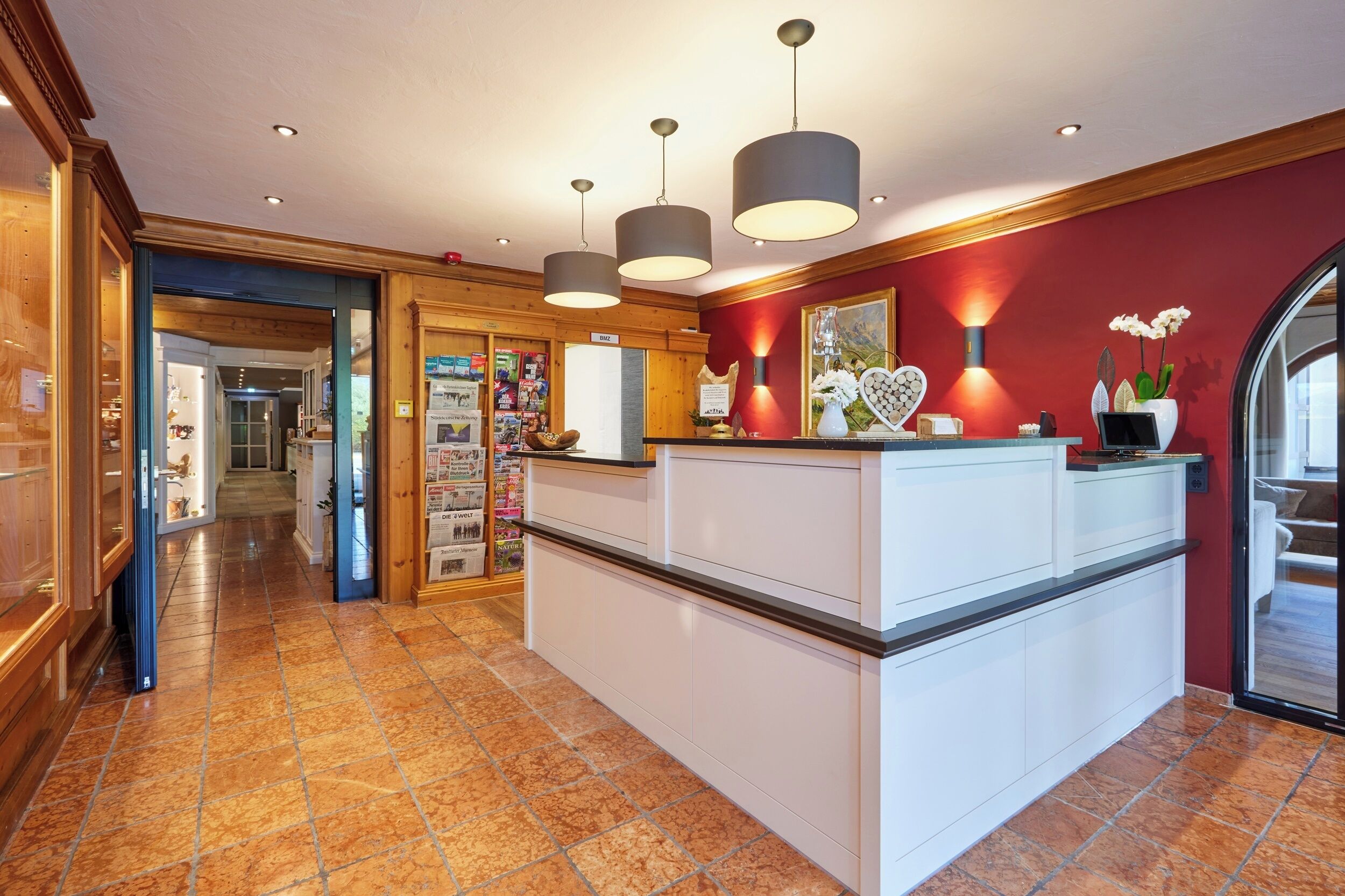 A hotel lobby with a reception desk, a large island, and a view of the interior.