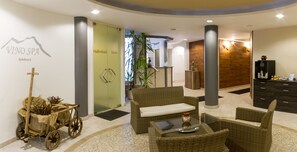 A spa area with wicker furniture, a sauna entrance, and a reception desk.