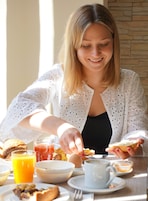 A breakfast setting with a table, plates, and a glass of orange juice.