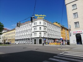 Um edifício de esquina com uma placa indicando 'Westbahn Hotel'.