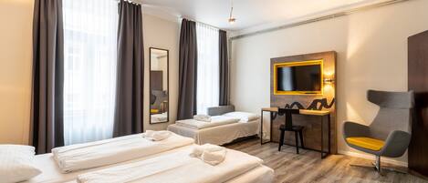 Een hotelkamer met twee bedden, een bureau, een stoel, een televisie en een spiegel.
