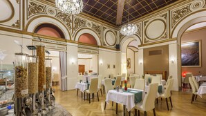A dining area with marble counters, white tablecloths, and chandeliers. - Hotel Wandl (Vienna)