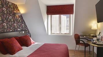 A bedroom with a bed, a desk, and a chair.