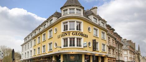 A corner building with the sign "Le Saint Georges" on the facade.