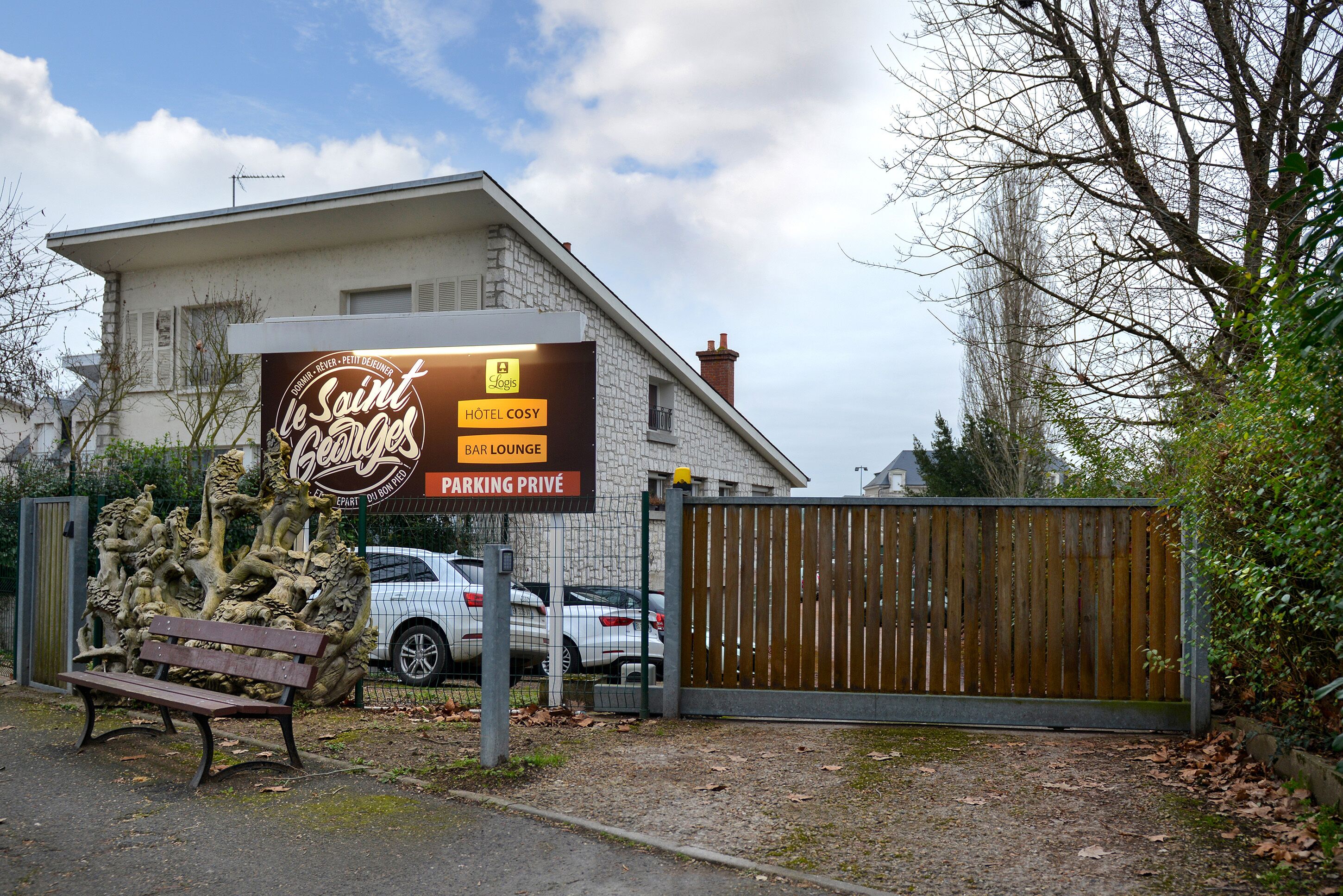 A hotel sign with amenities including a bar lounge and private parking.