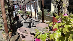 An outdoor patio area with wicker furniture and potted plants. - Logis Hôtel le St Georges Vendôme (Vendome)