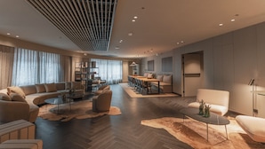 A spacious living area with a sofa set, a dining table, and a coffee table.