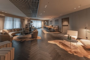 A spacious living area with a sofa set, a dining table, and a coffee table.