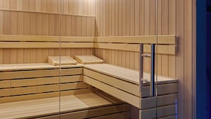 Una sauna con bancos de madera y un panel de vidrio.