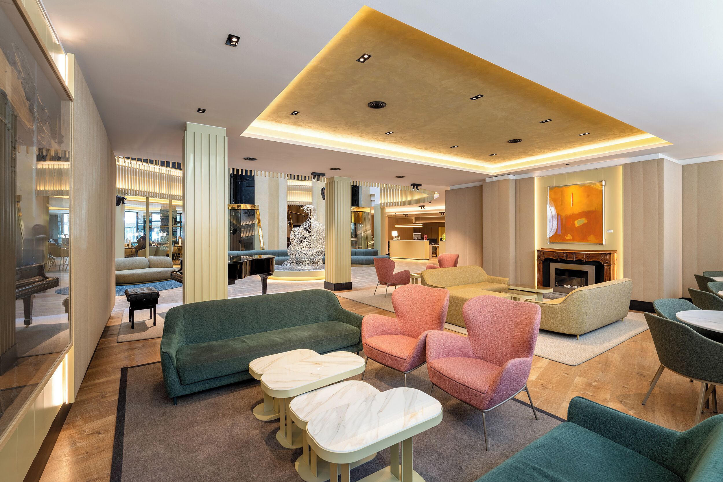 A spacious lobby with seating areas, a piano, and a fireplace.