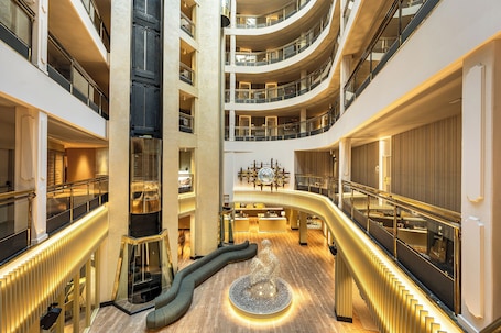 Un atrio a più livelli con una scala a spirale centrale, diversi balconi e un lampadario sontuoso.. Grand Plaza Hotel & Wellness
