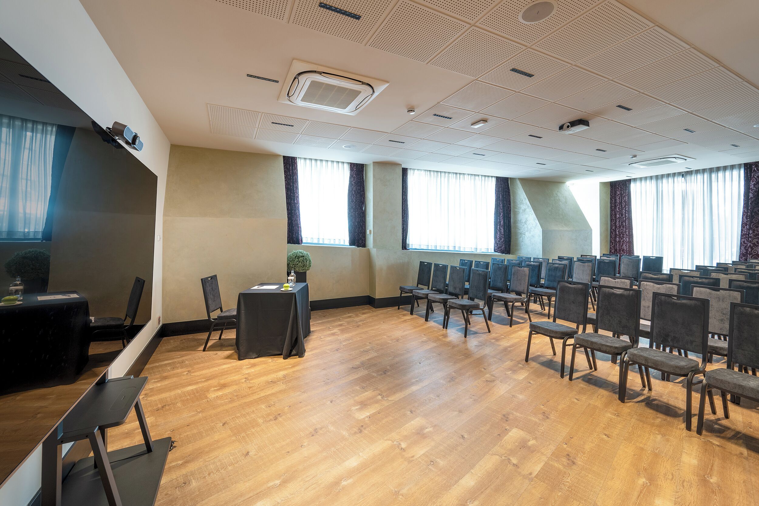 Une salle de conférence équipée d’une longue table, de chaises et d’un projecteur.