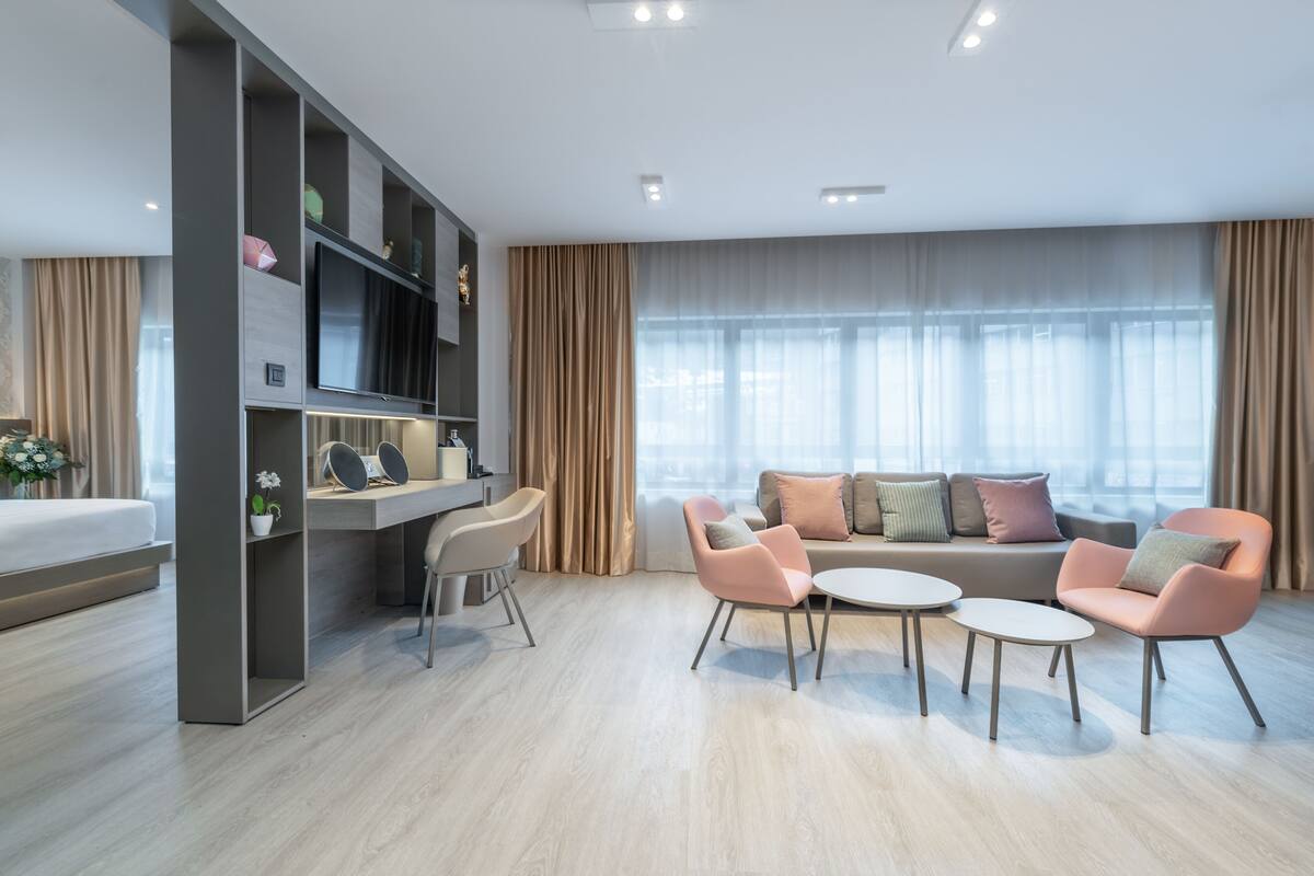 A modern living room with a sofa set, a coffee table, and a TV mounted on a wall.