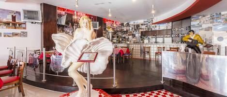 A bar area with a checkered floor, a statue, and a bar counter.