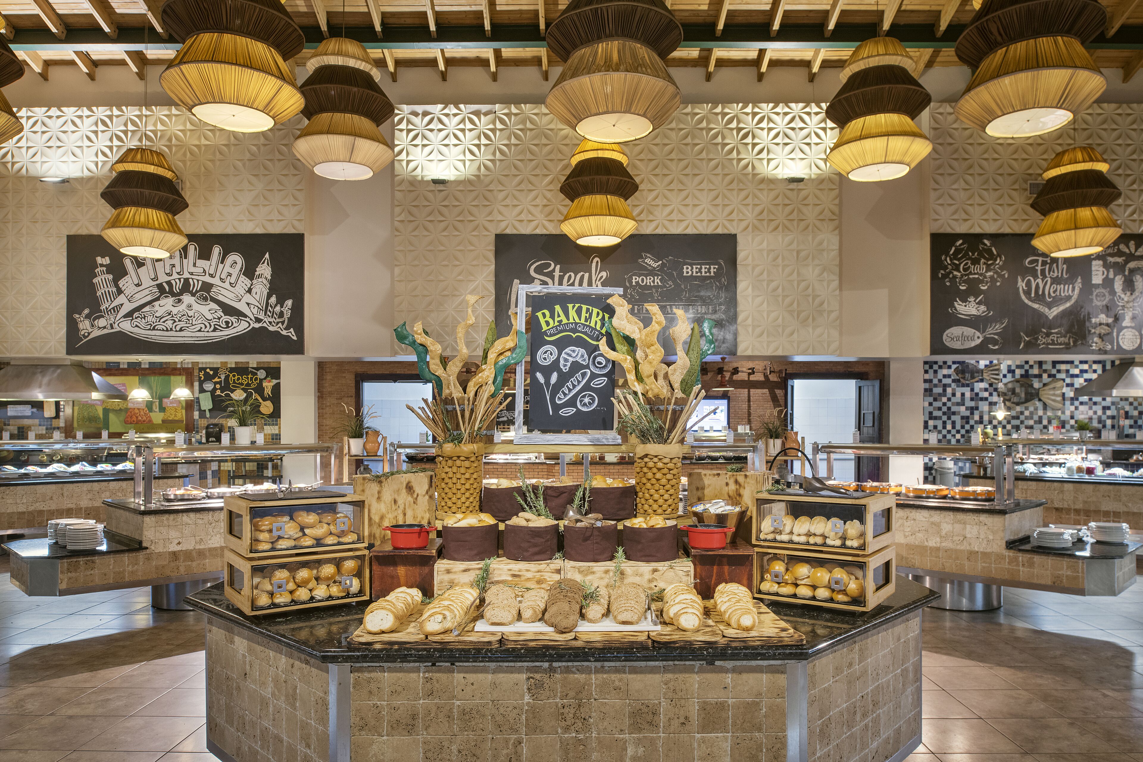 A buffet area with various food items and a central display of baked goods.