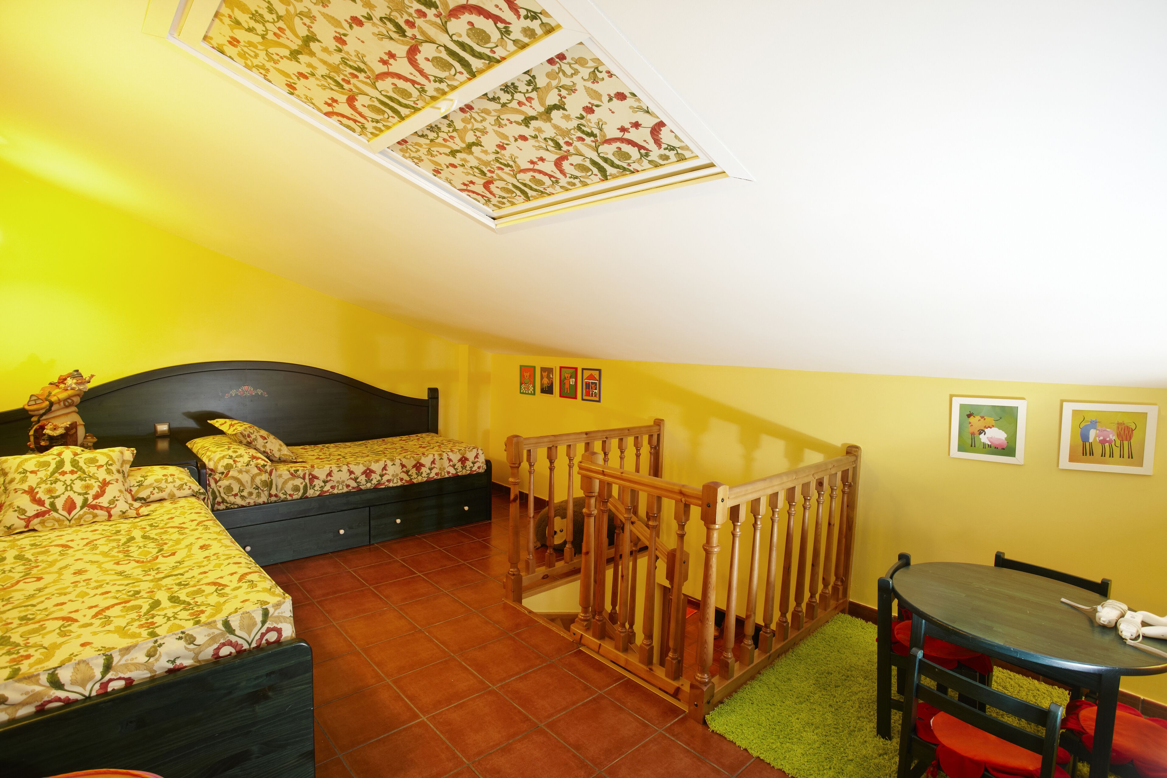 Un dormitorio con dos camas, una escalera de madera, una mesa de comedor y una alfombra verde.