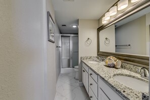 A bathroom with a large mirror, a sink, and a shower. - Carolina Dunes (Myrtle Beach)