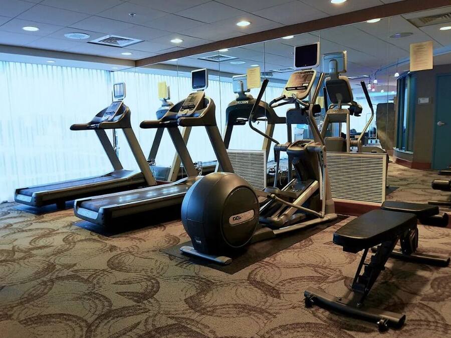 A hotel fitness center with treadmills, elliptical machines, and a rowing machine.