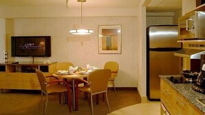 Une chambre d’hôtel compacte comprenant un coin repas, une télévision, un réfrigérateur et un four à micro-ondes.