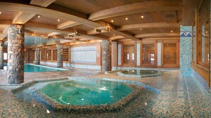 A spa area with multiple pools, stone pillars, and tiled walls. - CGH Résidences & Spas Le Hameau du Beaufortain (Villard-sur-Doron)
