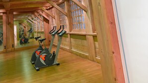 A gym with wooden beams and large windows. - CGH Résidences & Spas Le Hameau du Beaufortain (Villard-sur-Doron)