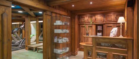 A wooden interior with a treadmill, a glass display case, and wooden cabinets.