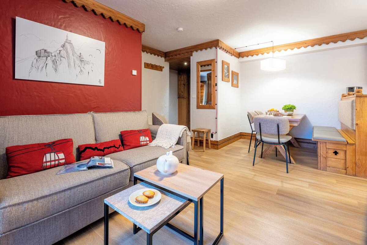 Ein Wohnzimmer mit einer Couch, einem Couchtisch und einem Essbereich mit Tisch und Stühlen.