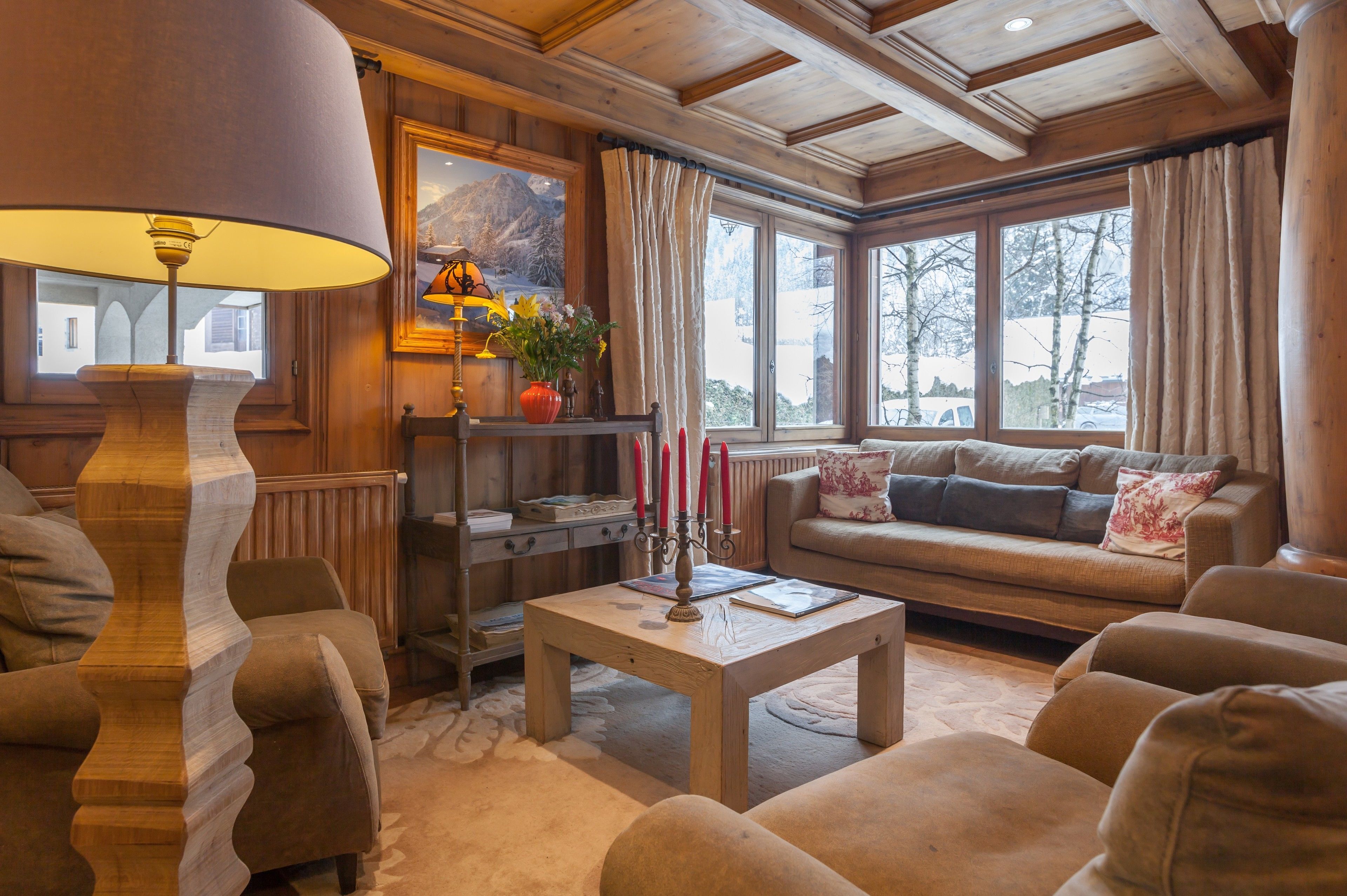 A cozy living room with a wooden ceiling, a sofa, a coffee table, and a lamp.