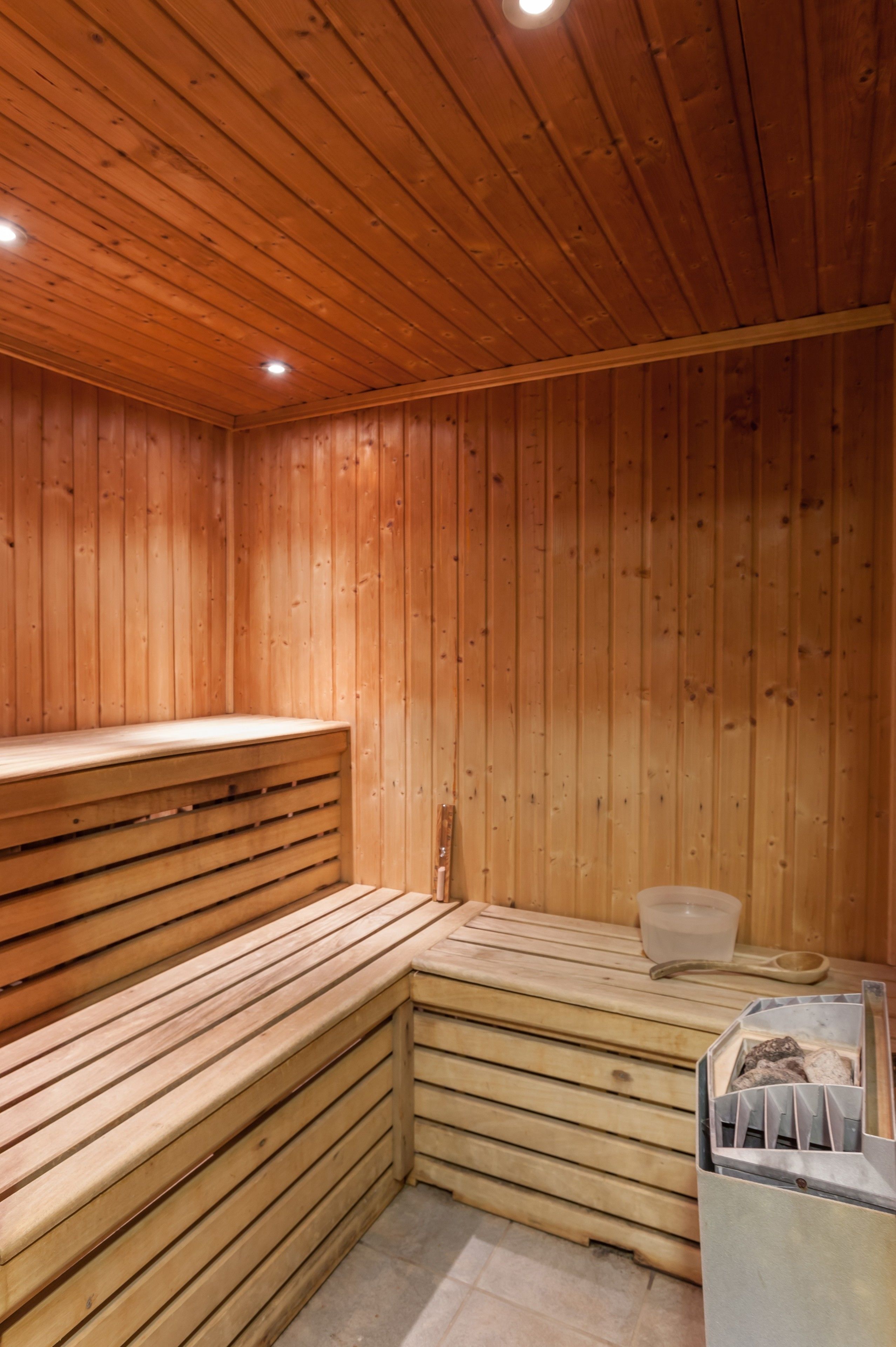 Un sauna avec des bancs en bois et une banquette.