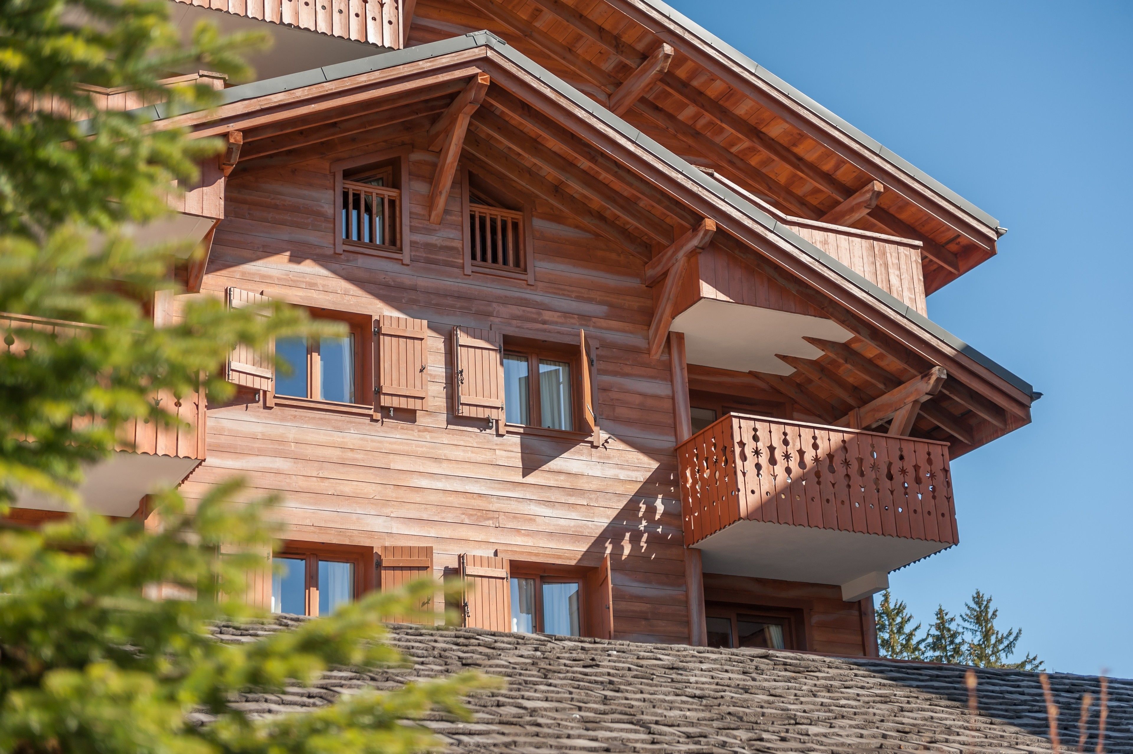A multi-story wooden building with balconies and windows.