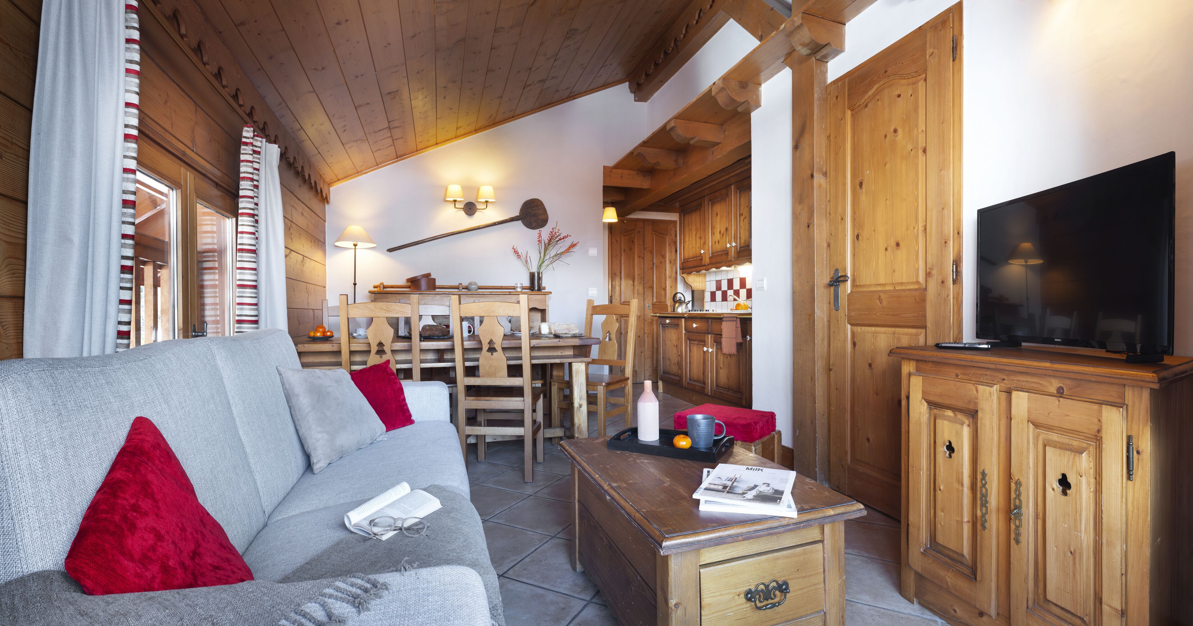 A cozy living room with a sofa, a coffee table, and wooden cabinets.