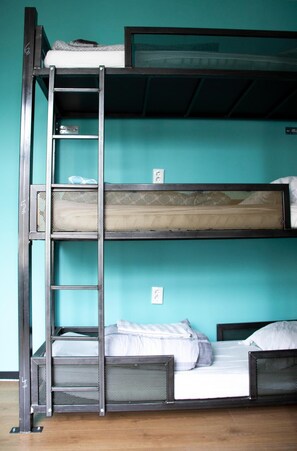 A bunk bed with a ladder, a mesh headboard, and a teal wall. - Amsterdam Hostel Leidseplein (Amsterdam)