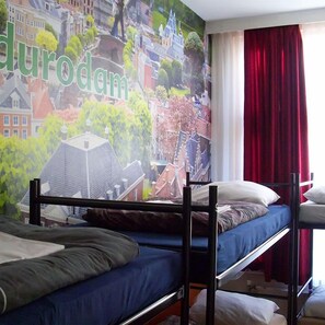 A room with bunk beds, a mural of a cityscape, and a red curtain. - Amsterdam Hostel Leidseplein (Amsterdam)