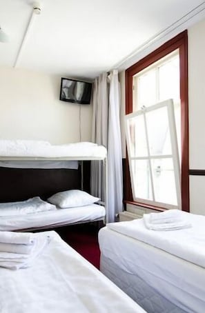 A hotel room with two beds, a TV mounted on the wall, and a window with curtains. - Marnix Hotel (Amsterdam)