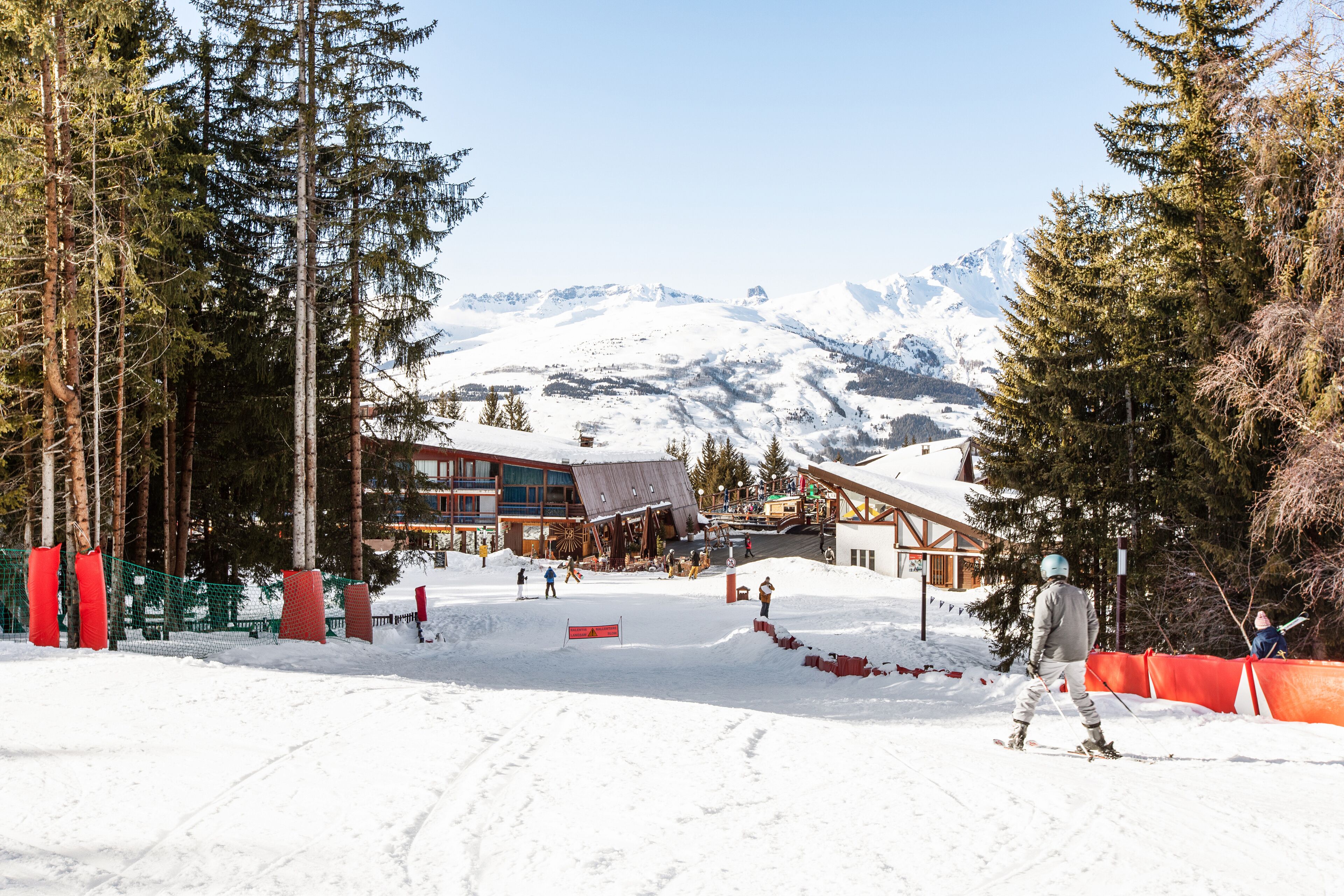 A ski resort with a mountain backdrop, including a lodge and ski slopes.