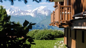 A wooden chalet with a balcony overlooking a mountain range. - Résidence Pierre & Vacances Premium Les Alpages de Chantel (Bourg-Saint-Maurice)