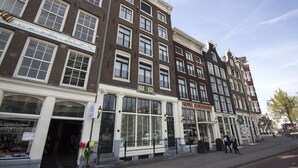 Filera d'edificis de tipus europeu tradicional, amb botigues a la planta baixa i un hotel anomenat "HOTEL MARS" a la dreta.