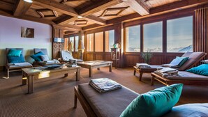 A wooden-floored lounge area with seating and a view of mountains. - Résidence Pierre & Vacances Premium Les Hauts Bois (Aime-la-Plagne)