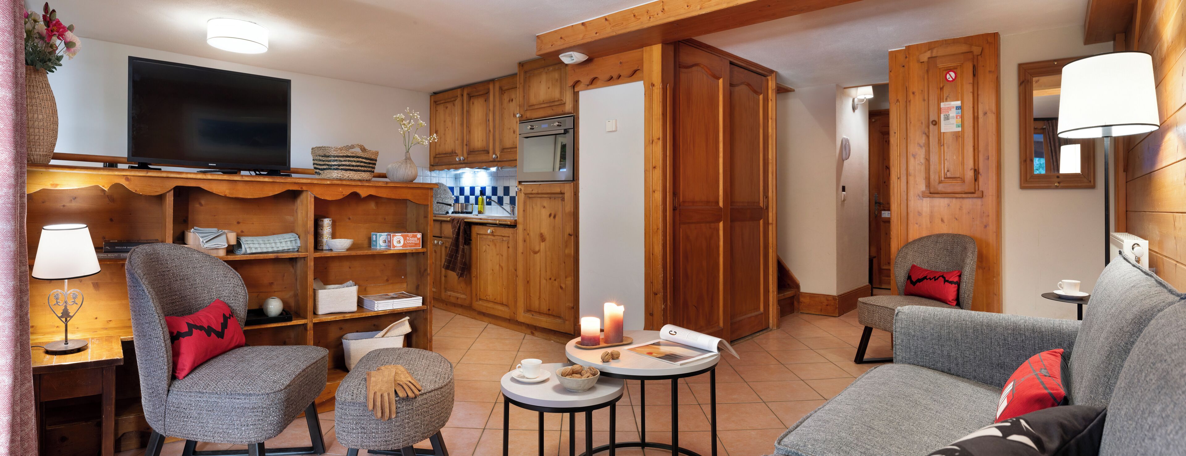 A cozy living room with a TV, wooden cabinets, and a fireplace.