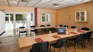 A conference room with a long table, chairs, water bottles, and a laptop.