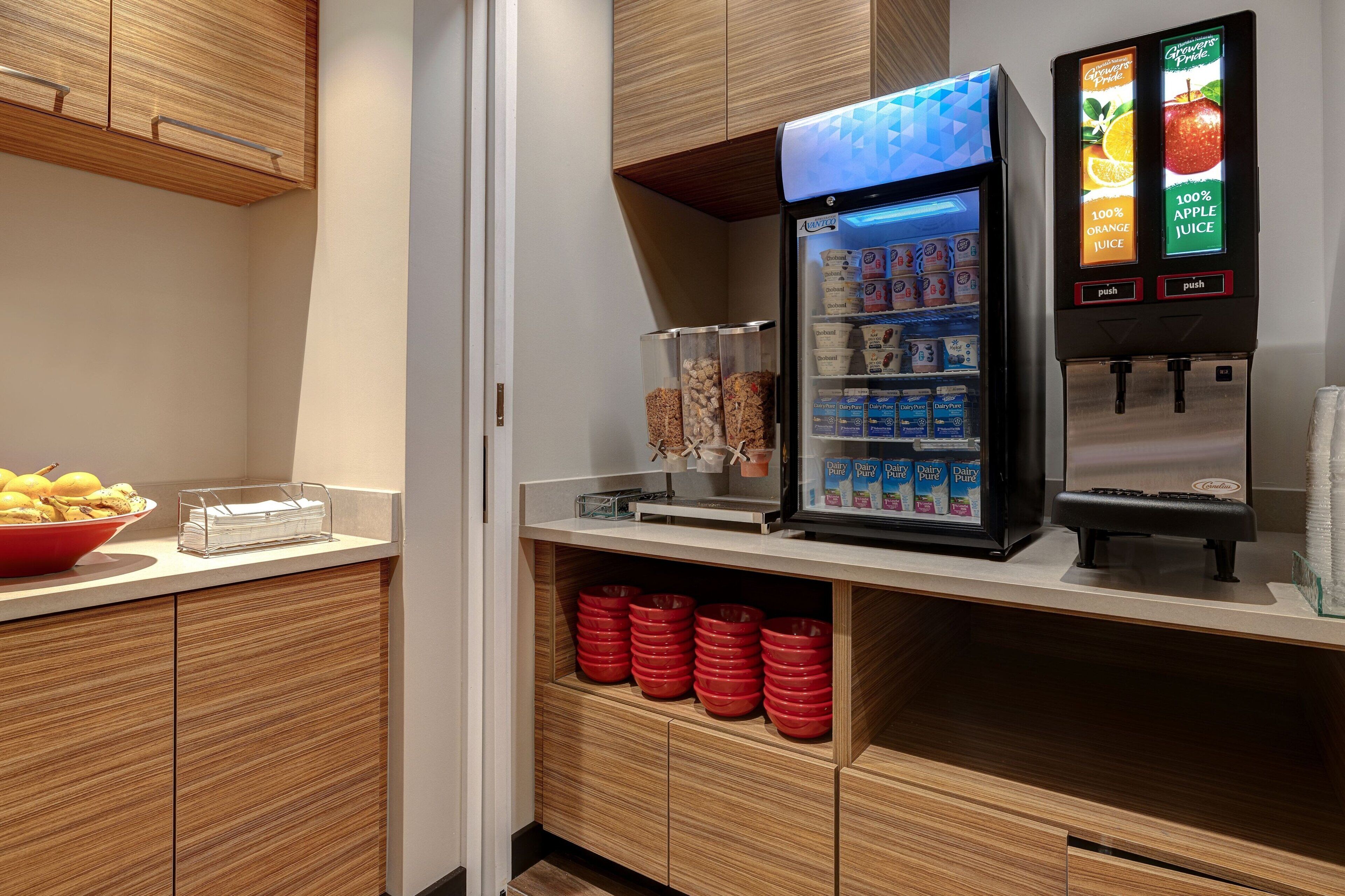 A self-service beverage station with refrigerated drinks and a milk dispenser.