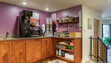 A kitchen with wooden cabinets, a microwave, a coffee maker, and a refrigerator.
