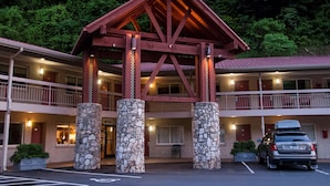 A motel with a stone pillar entrance, a balcony, and a parking area. -  Econo Lodge Cherokee Near Island Park (Cherokee)