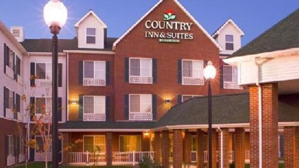 A Country Inn & Suites building with a brick facade, multiple windows, and a sign above the entrance. - Country Inn & Suites by Radisson, Duluth North, MN (Duluth)