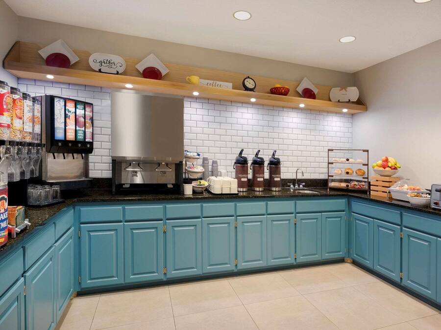 Eine moderne Küche mit blauen Schränken, einer Kaffeestation und diversen Geräten.