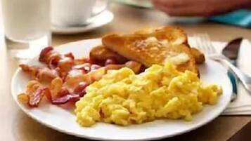 A breakfast plate with eggs, bacon, and toast.